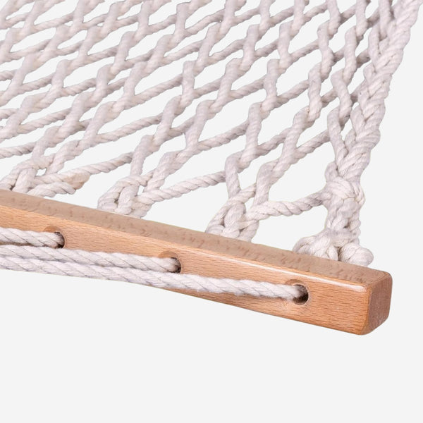 Close-up of a white rope hammock with wooden slats on a light gray background