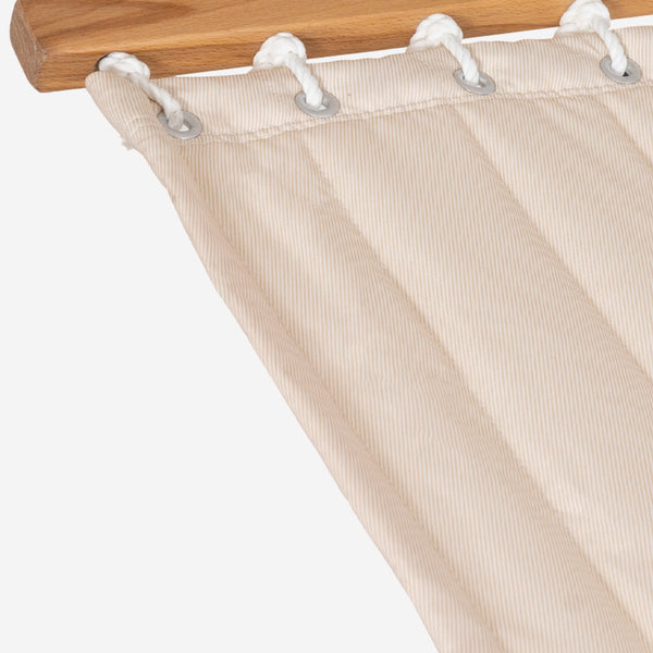 Beige hammock with white eyelets on a wooden frame against a white background