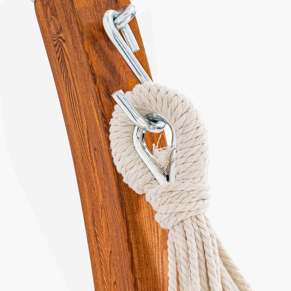 Close-up of a wooden post with a rope and metal hook on a white background