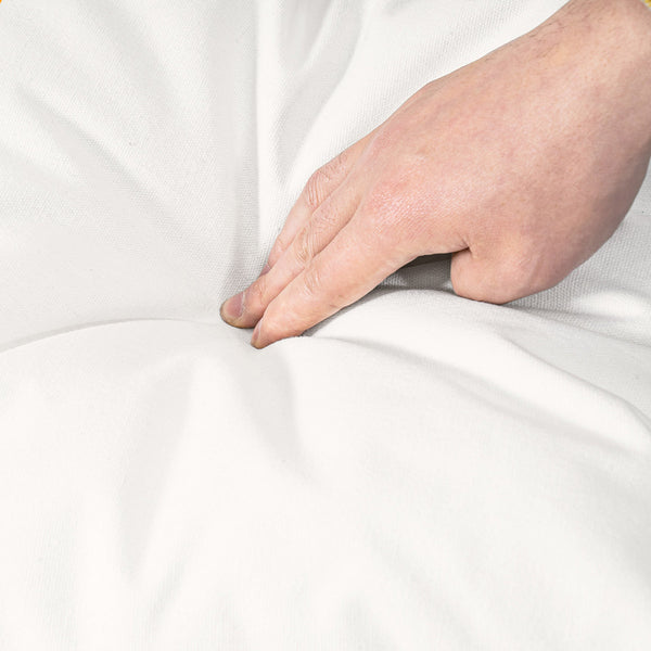 Hand touching a white fabric surface