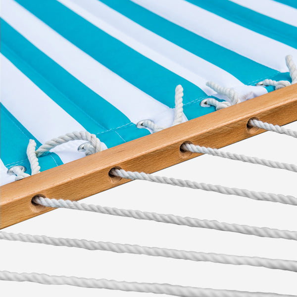 Close-up of a hammock with blue and white striped canopy and wooden frame.