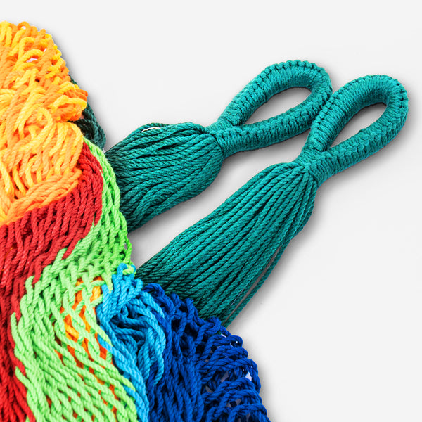 Colorful knitted or crocheted bags with handles on a light gray background