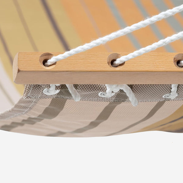 Close-up of a hammock with wooden slats and white ropes on a neutral background