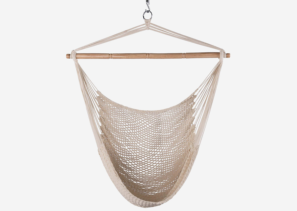 Beige hammock chair hanging against a white background