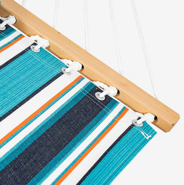 Close-up of a striped hammock with wooden frame and metal clips.