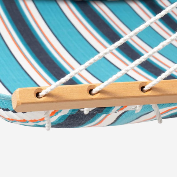 Close-up of a hammock with wooden slat and striped fabric background