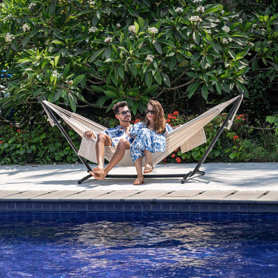 Cozy backyard setup with a Lazy Daze Brazilian Premium Polycotton Hammock and a couple relaxing.#color_natural