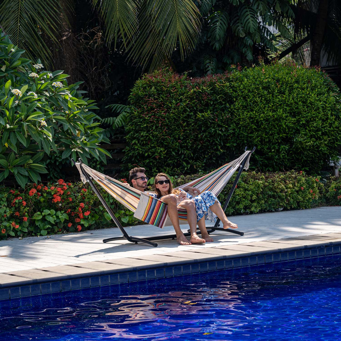 Man and woman enjoying on Lazy Daze Brazilian Premium Polycotton Hammock in a peaceful backyard.#color_tan-stripes