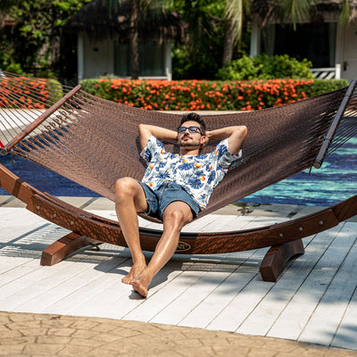 Enjoying the sun on Lazy Daze Double Caribbean Rope Hammock in Brown by the pool.#color_brown