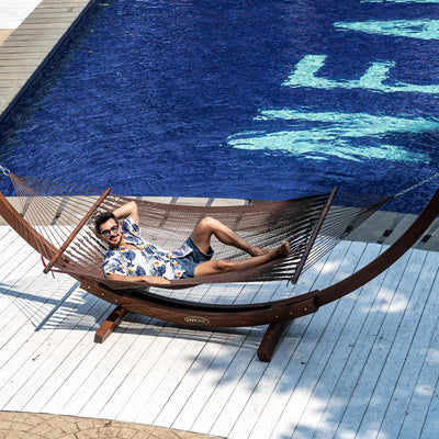 Brown Lazy Daze Double Caribbean Rope Hammock with person lounging in the backyard.#color_brown