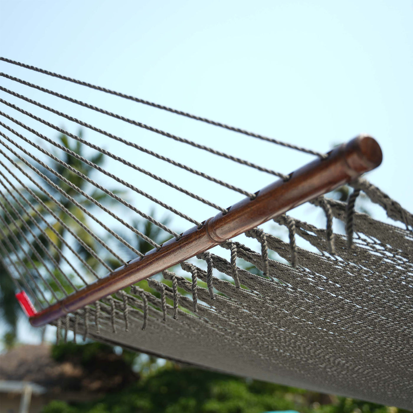 Detailed view of the hardwood spreader bar on the Lazy Daze Double Caribbean Rope Hammock in Gray. #color_gray