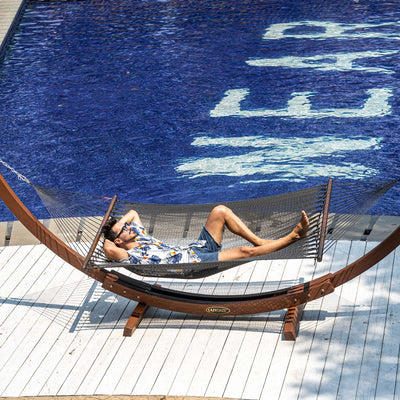 Gray Lazy Daze Double Caribbean Rope Hammock with person lounging by poolside.#color_gray