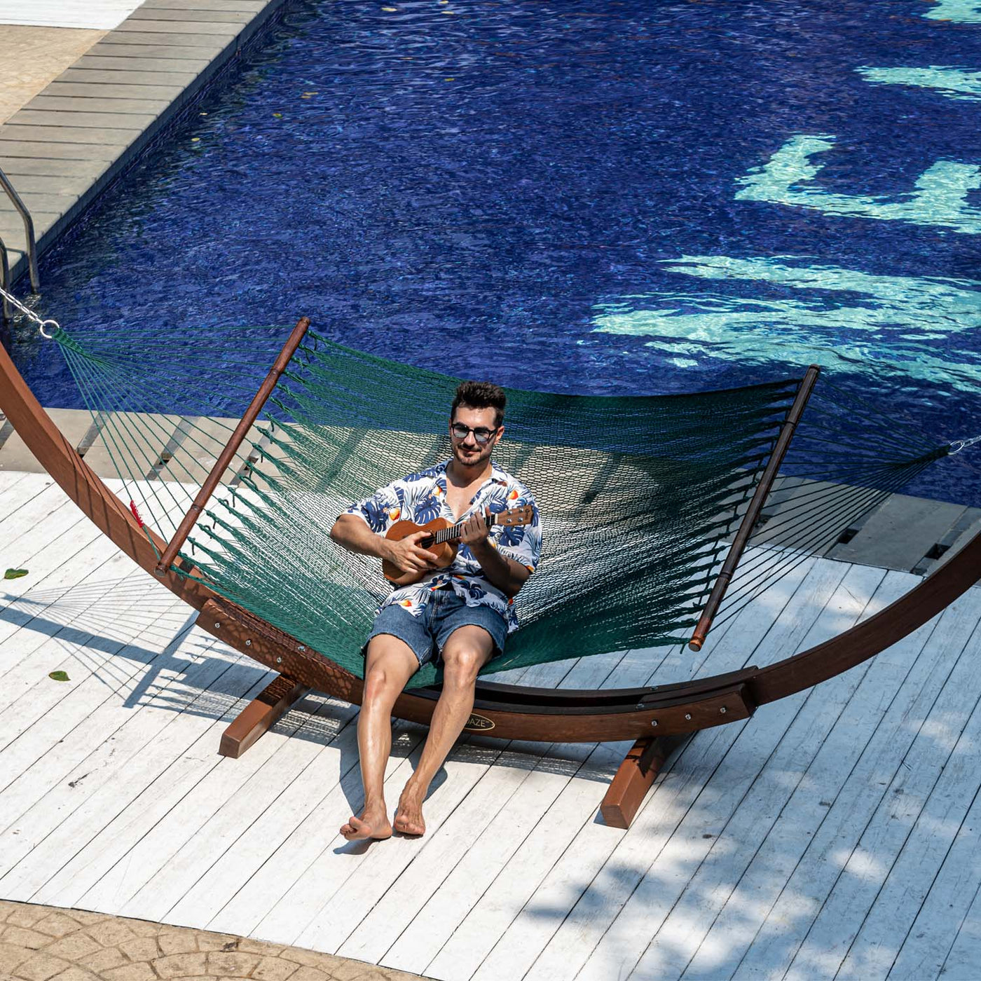 Relaxing in the Lazy Daze Double Caribbean Rope Hammock in Green by the poolside.#color_green