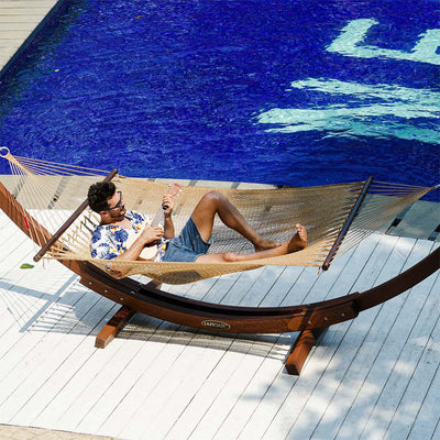 Lazy Daze Double Caribbean Rope Hammock in Tan - Relaxing poolside scene with a person lounging #color_tan