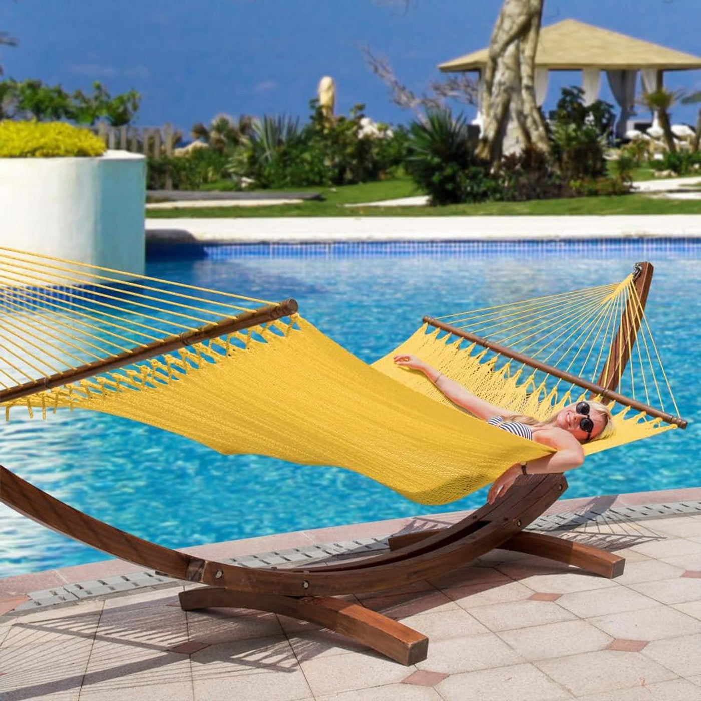 Lazy Daze Double Caribbean Rope Hammock in Yellow displayed by the poolside.#color_yellow