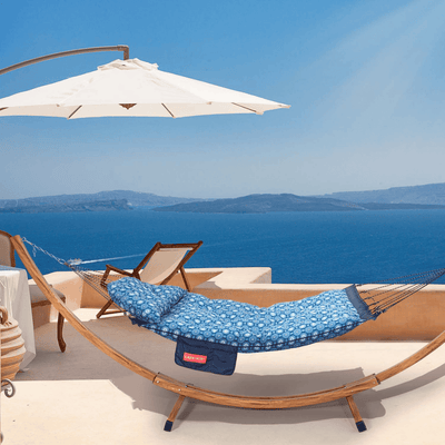 Lazy Daze Double Hammock with Curved Spreader Bar in navy displayed on a balcony overlooking the sea.#color_navy