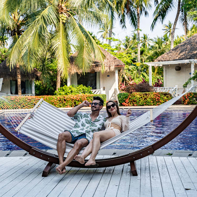 Couple relaxing on Lazy Daze Double Poolside Hammock in Beige White Stripes by the poolside.#color_beige-white-stripes