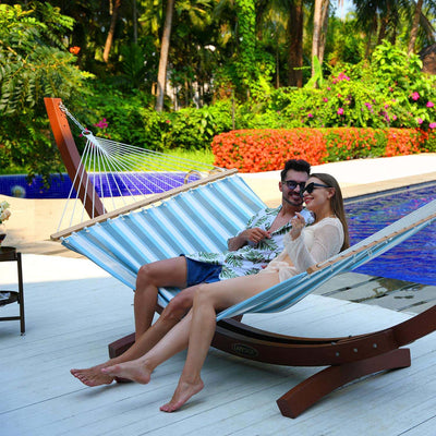 Couple relaxing on the Lazy Daze Double Poolside Hammock in Blue White Stripes in the backyard.#color_blue-white-stripes