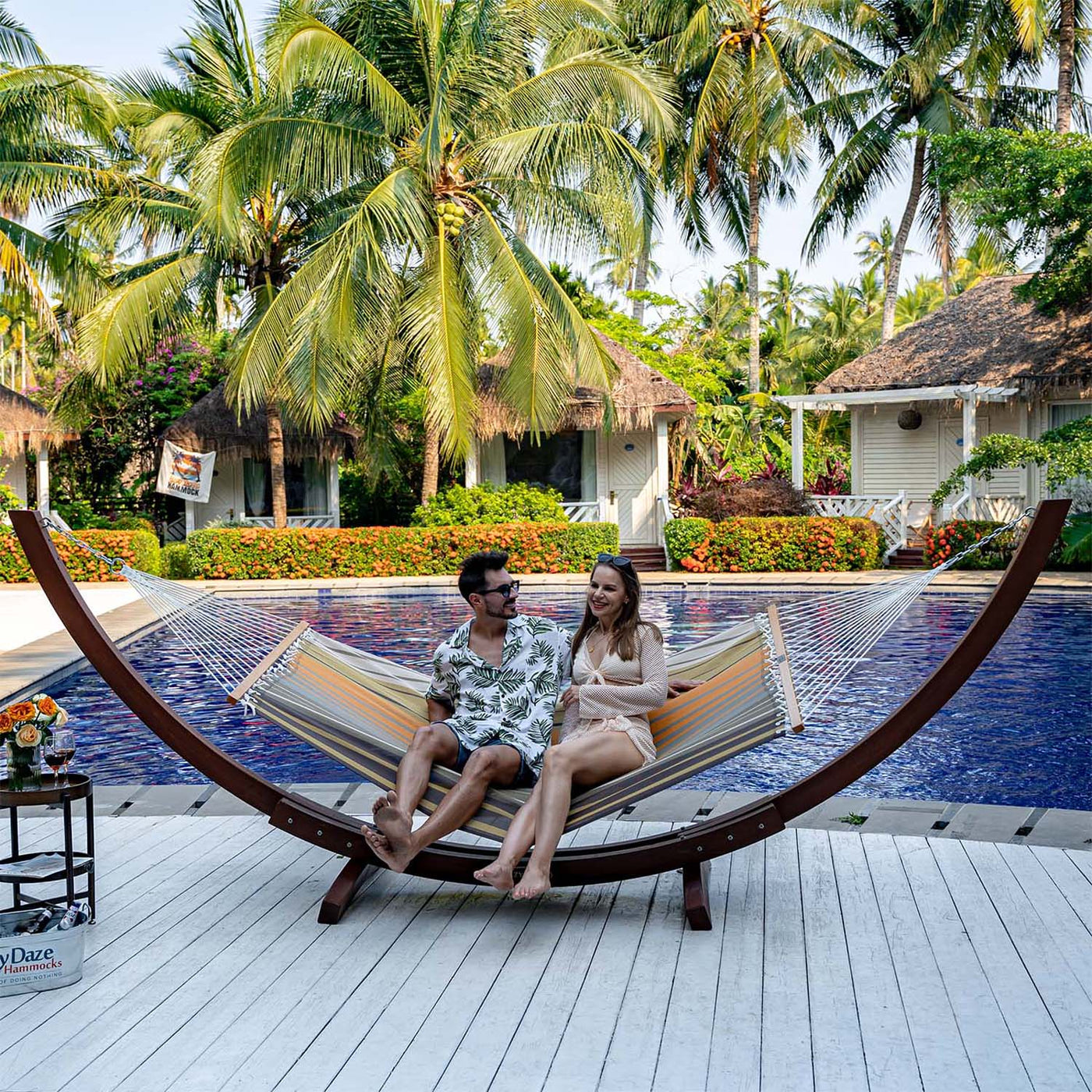 Couple relaxing on Lazy Daze Double Poolside Hammock in Coffee Stripes by the poolside.#color_coffee-stripes