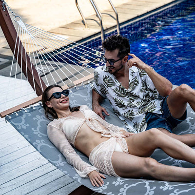 Couple relaxing on the Lazy Daze Double Poolside Hammock in Four Leaf Clover in the backyard.#color_four-leaf-clover