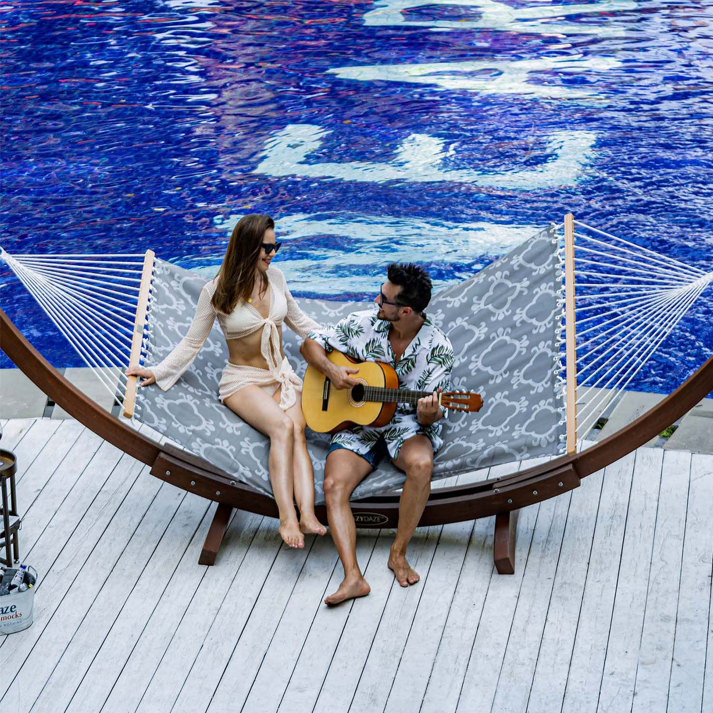 Friends unwinding on the Lazy Daze Double Poolside Hammock in Four Leaf Clover by the poolside.#color_four-leaf-clover