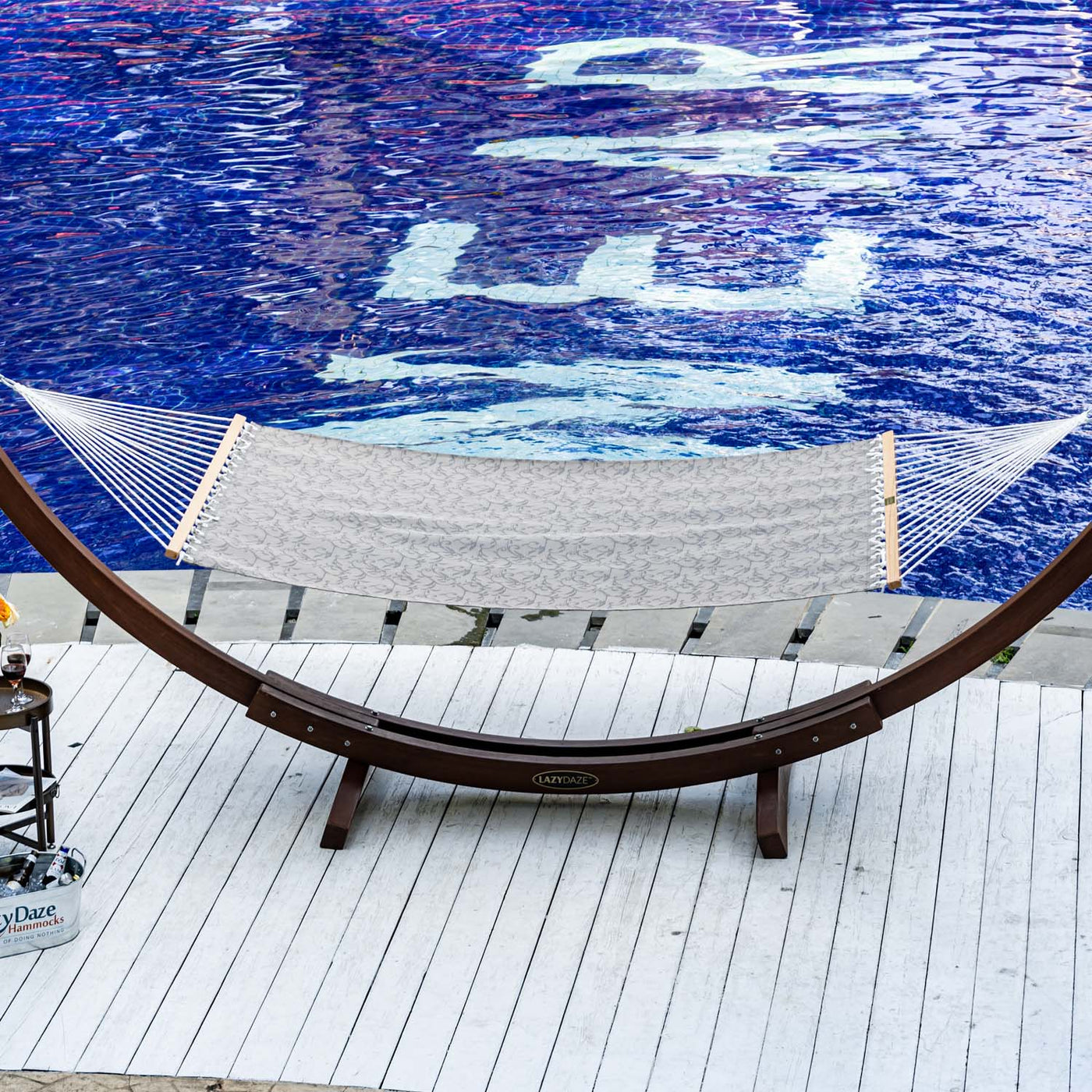 Lazy Daze Double Poolside Hammock in Vines positioned elegantly by the pool, showcasing its sturdy design.#color_vines