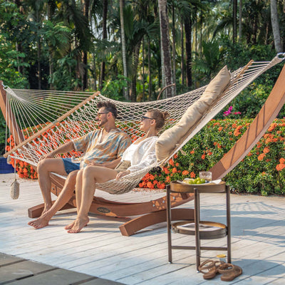 Couple relaxing on the Lazy Daze Double Traditional Cotton Rope Hammock in the backyard.#color_natural