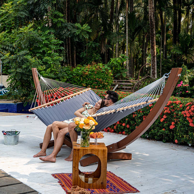 Lazy Daze large double quilted hammock in dark gray, a couple relaxing together in a serene backyard setting.#color_dark-gray