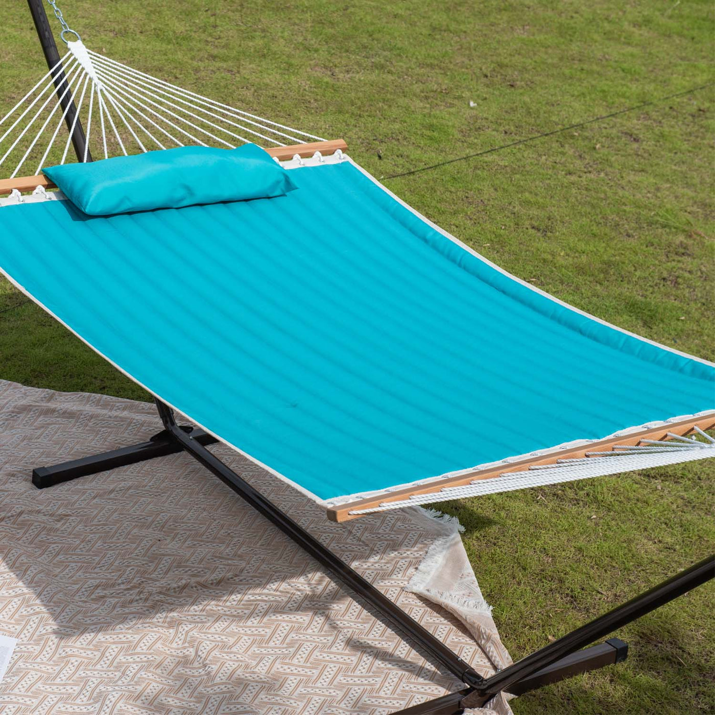 Lazy Daze large double quilted hammock in sky blue resting on the grass in a peaceful outdoor setting.#color_sky-blue