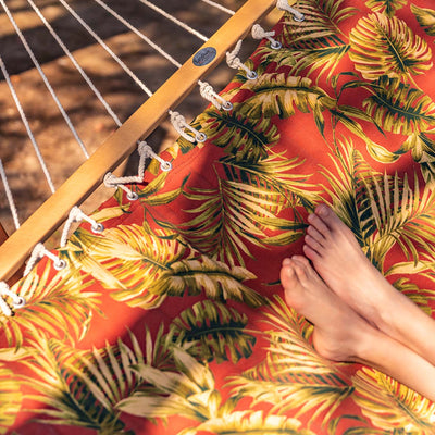 Close-up of Lazy Daze floral red reversible hammock showing the hardwood spreader bar and floral print.#color_floral-red