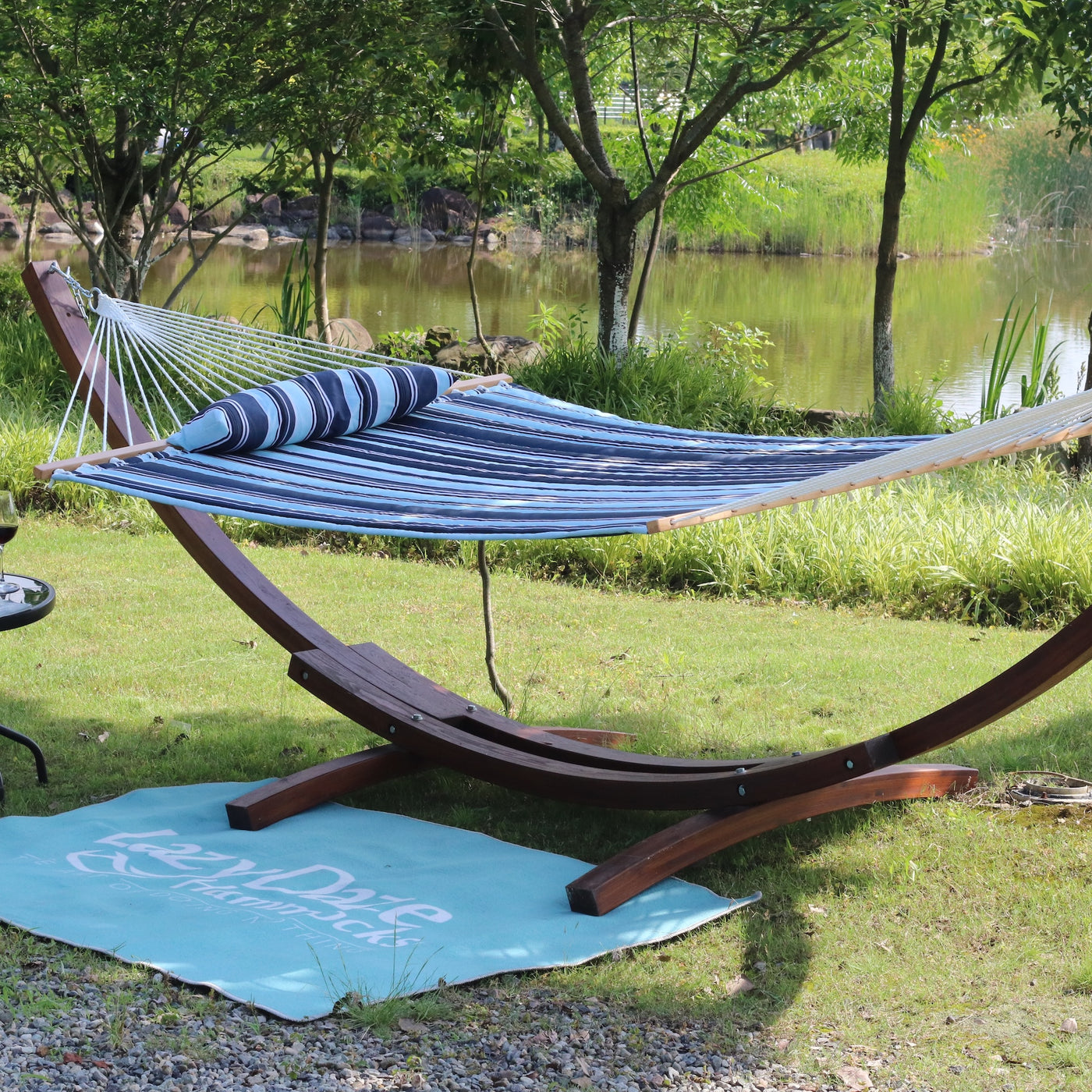 Lazy Daze double stripes hammock resting on a grassy area, perfect for outdoor relaxation.#color_aqua-navy