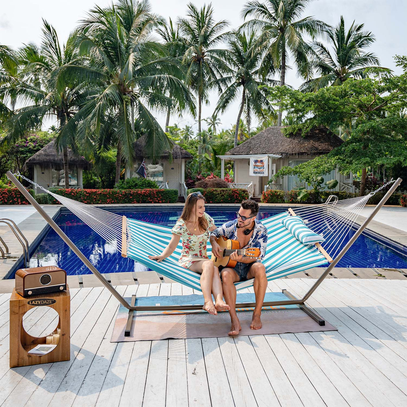 Relaxing scene with a couple on the Lazy Daze Large Double Stripes Quilted Hammock.#color_aqua-white-stripes