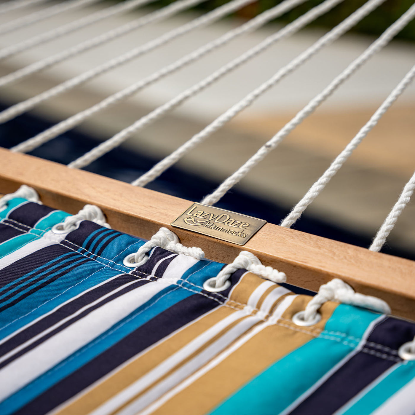 Hardwood spreader bar detail on the Lazy Daze Large Double Stripes Quilted Hammock in Beaches Stripes.#color_beaches-stripes