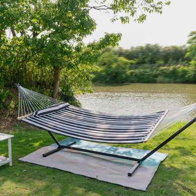 Black White Stripes Lazy Daze hammock set up in a peaceful grassy area by a lake.#color_black-white-stripes