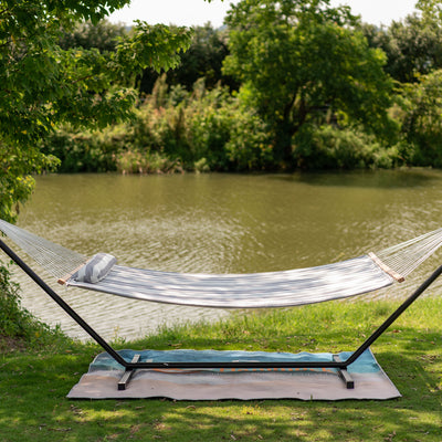 Large Double Double Quilted Hammock set up on a grassy shore near a tranquil lake.#color_gray-white-stripes