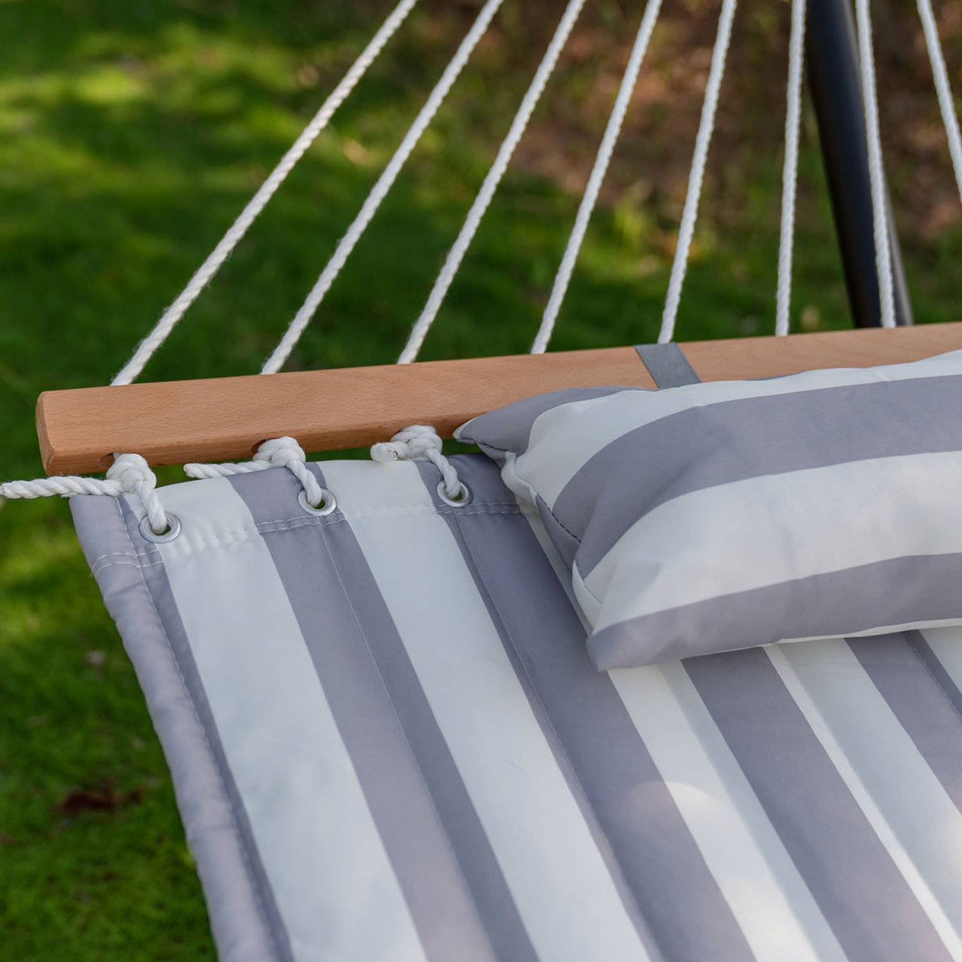 Highlight of the hardwood spreader bar and fabric on the Lazy Daze Quilted hammock.#color_gray-white-stripes