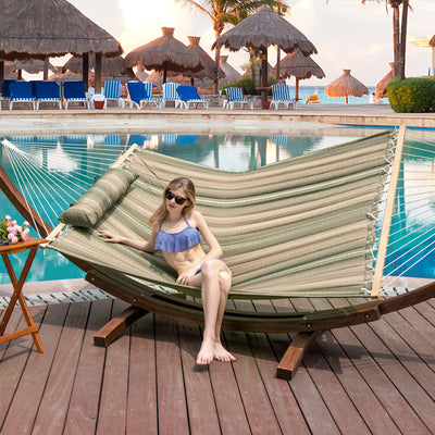 Lazy Daze Double Stripes Hammock in Green Brown with a woman lounging in a serene backyard setting.#color_green-brown-stripes