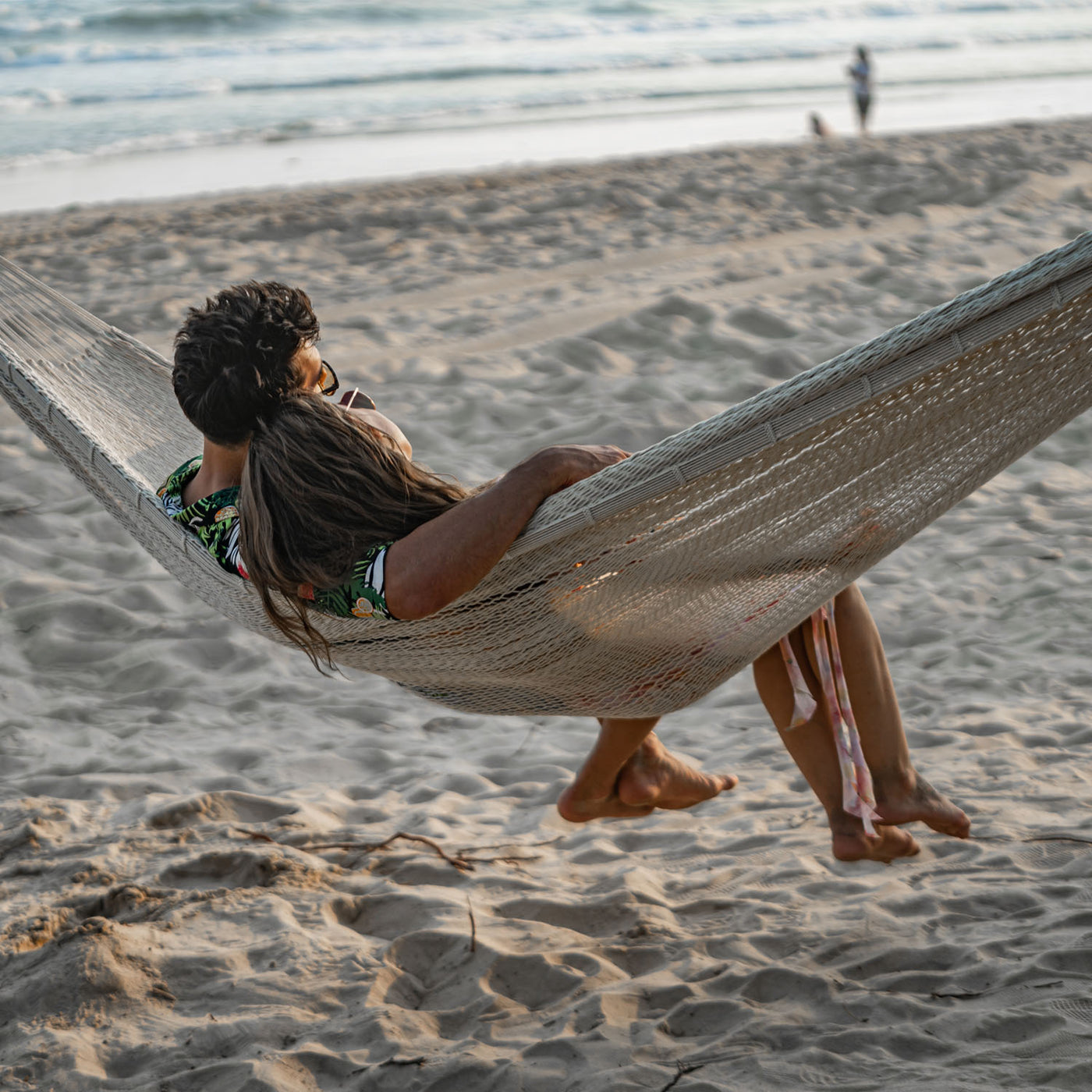 A couple enjoying the Lazy Daze Mayan Family Hammock in white at a beach.#color_white