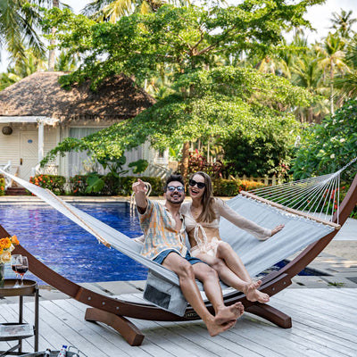 Couple lounging on the Lazy Daze Quick Dry Hammock in Gray in their backyard.#color_gray