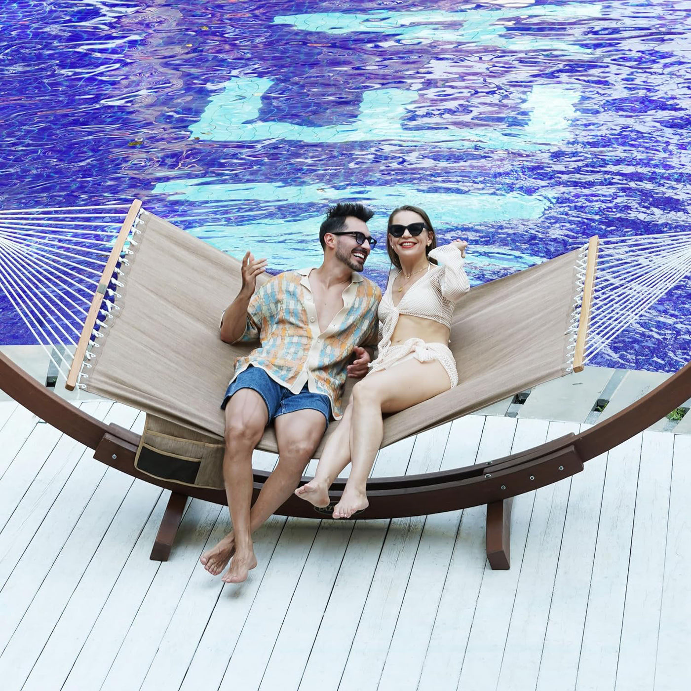 Couple relaxing on the Lazy Daze Quick Dry Hammock in Khaki by the poolside.#color_kahki