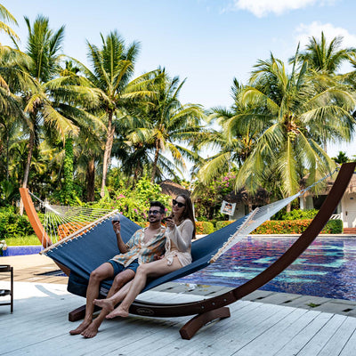 Couple lounging on the Lazy Daze Quick Dry Hammock in Navy Blue in their backyard.#color_navy-blue