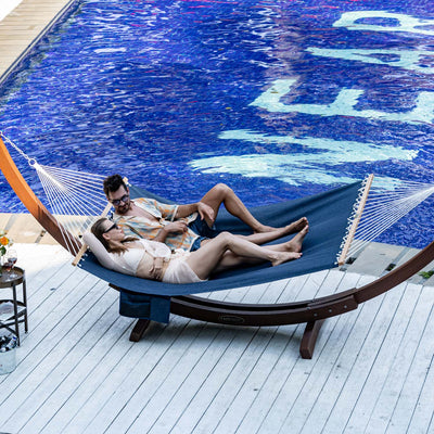 Man and woman enjoying the Lazy Daze Quick Dry Hammock in Navy Blue by the pool.#color_navy-blue