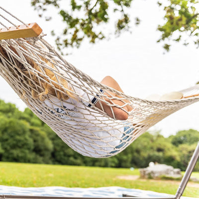 Lazy Daze rope hammock combo without cushion, durable steel stand, woman enjoying outdoors.#color_tan-pillow