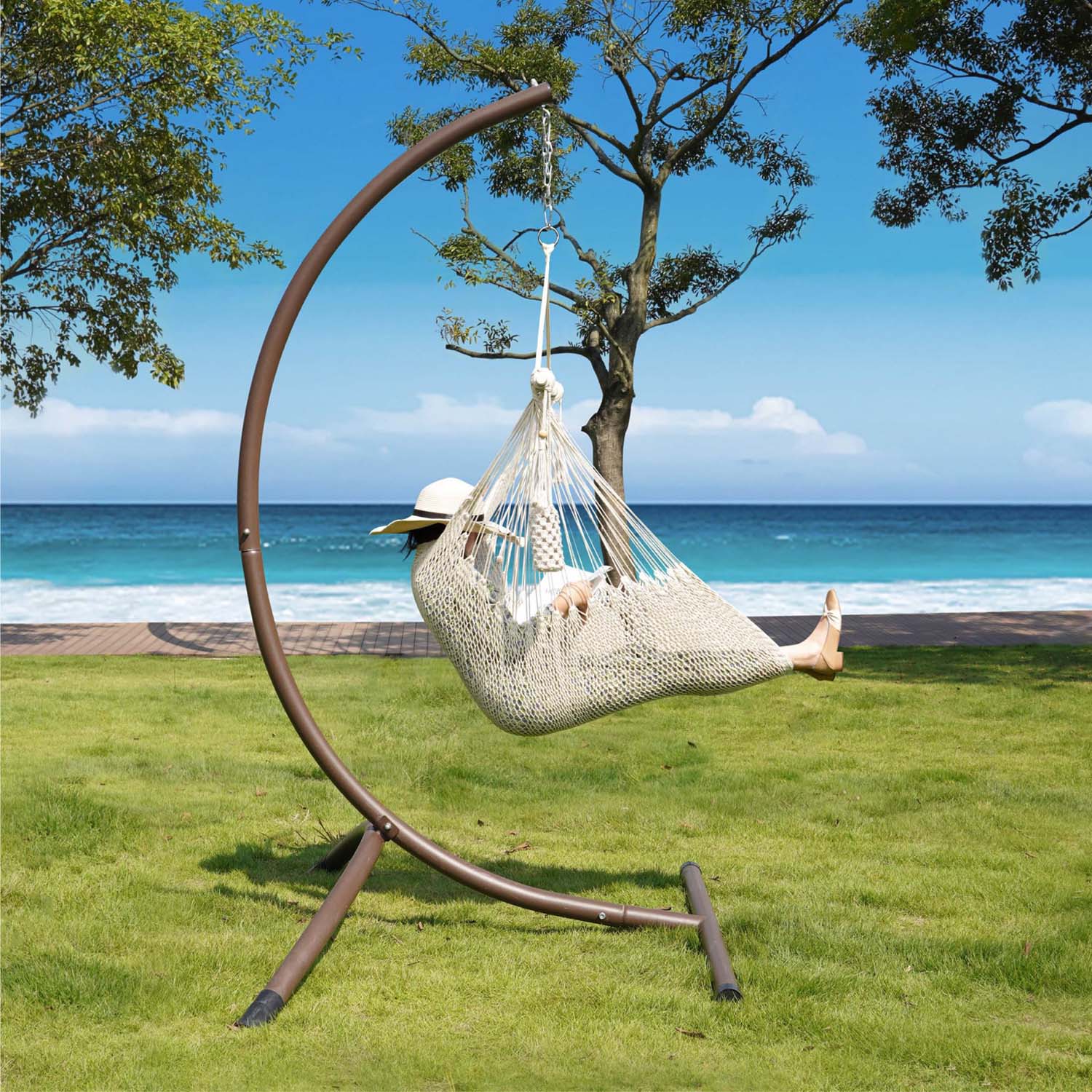 Enjoying comfort in Lazy Daze beige rope swing chair on the grass.#color_beige