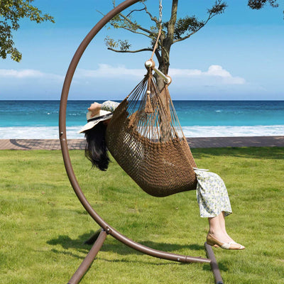 Enjoying the outdoors in Lazy Daze tan rope swing chair.#color_tan