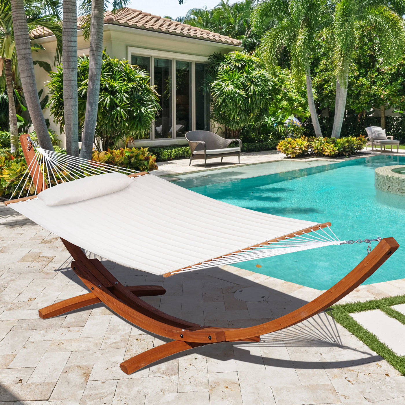 The Lazy Daze Sunbrella Double Quilted Hammock in Cream set up by the pool in a backyard.#color_cream