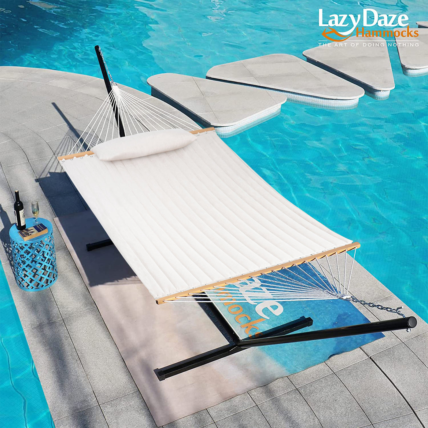 The Lazy Daze Sunbrella Double Quilted Hammock in Cream by a refreshing poolside.#color_cream