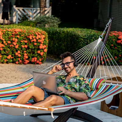 A person relaxing on the Lazy Daze Sunbrella Double Quilted Hammock in an outdoor setting.