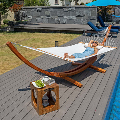 A woman relaxing in the Lazy Daze Sunbrella Single-layer Hammock, placed in a peaceful backyard.#color_cream