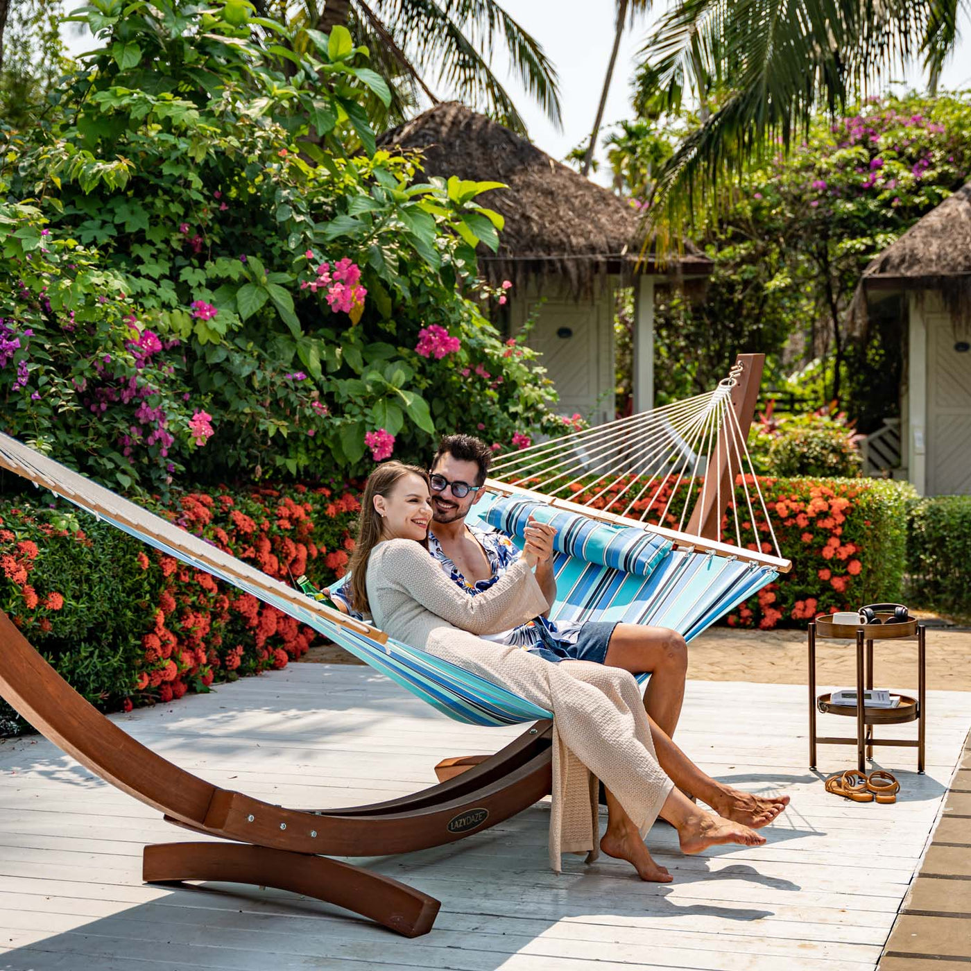 Couple lounging on Lazy Daze Sunbrella Single-layer Hammock, enjoying a sunny day in their garden.#color_gateway-mist